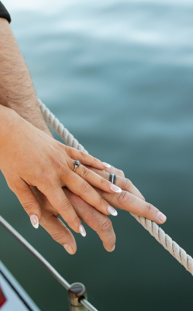 Hands of bride and groom showing wedding rings after their sailboat ceremony in Door County