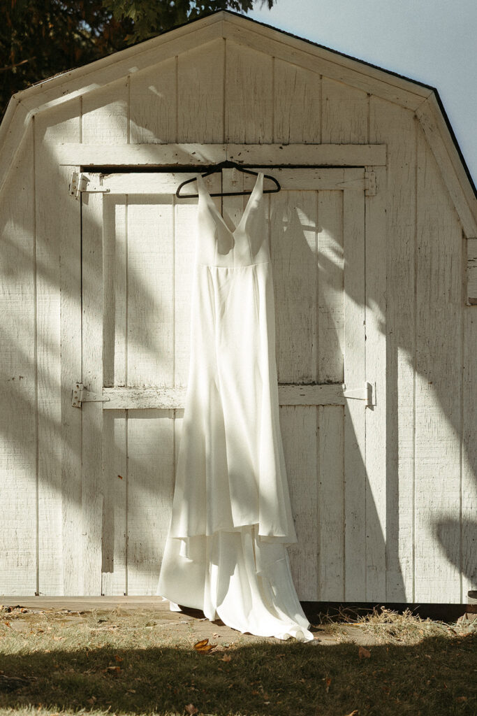 Bride's wedding dress hanging outside before an intimate Door County sailboat wedding