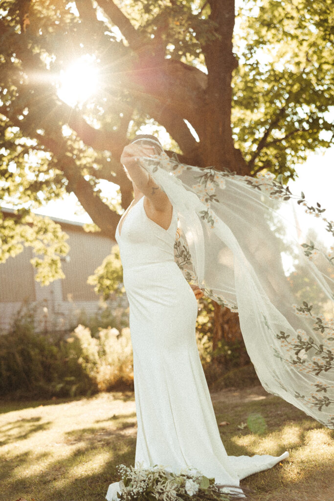 Bride holding her veil during golden hour portraits in Door County, Wisconsin 