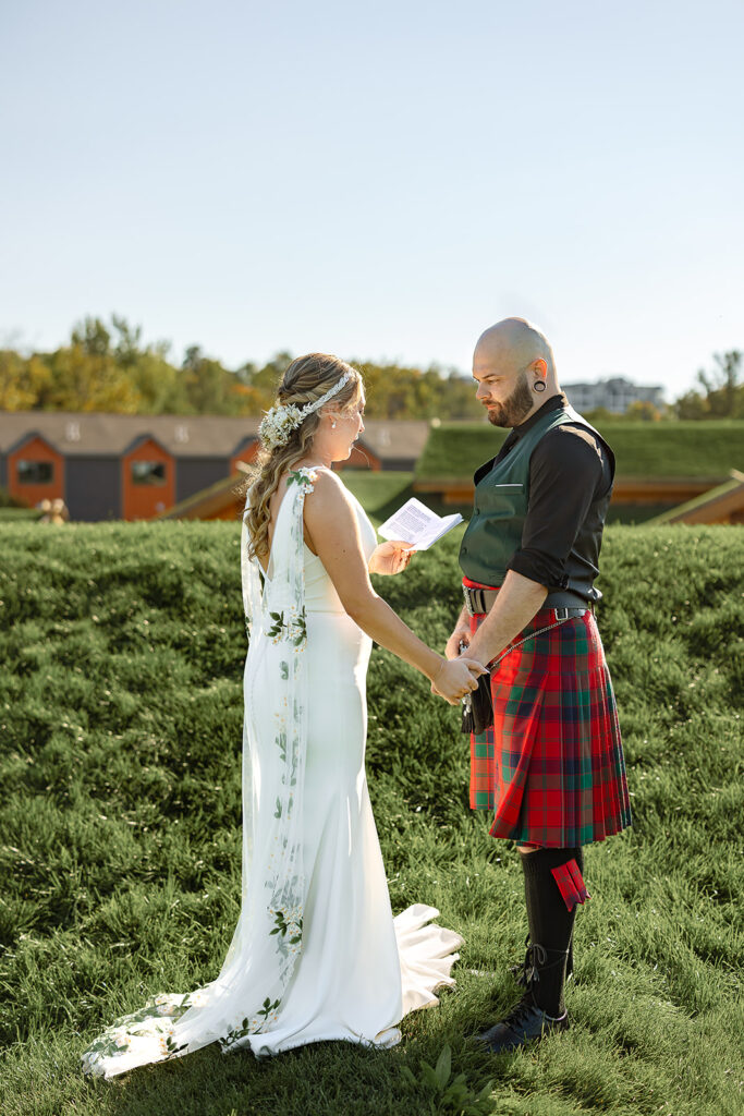 Bride and groom holding hands facing each other on the roof of Al Johnson's in Sister Bay, Door County