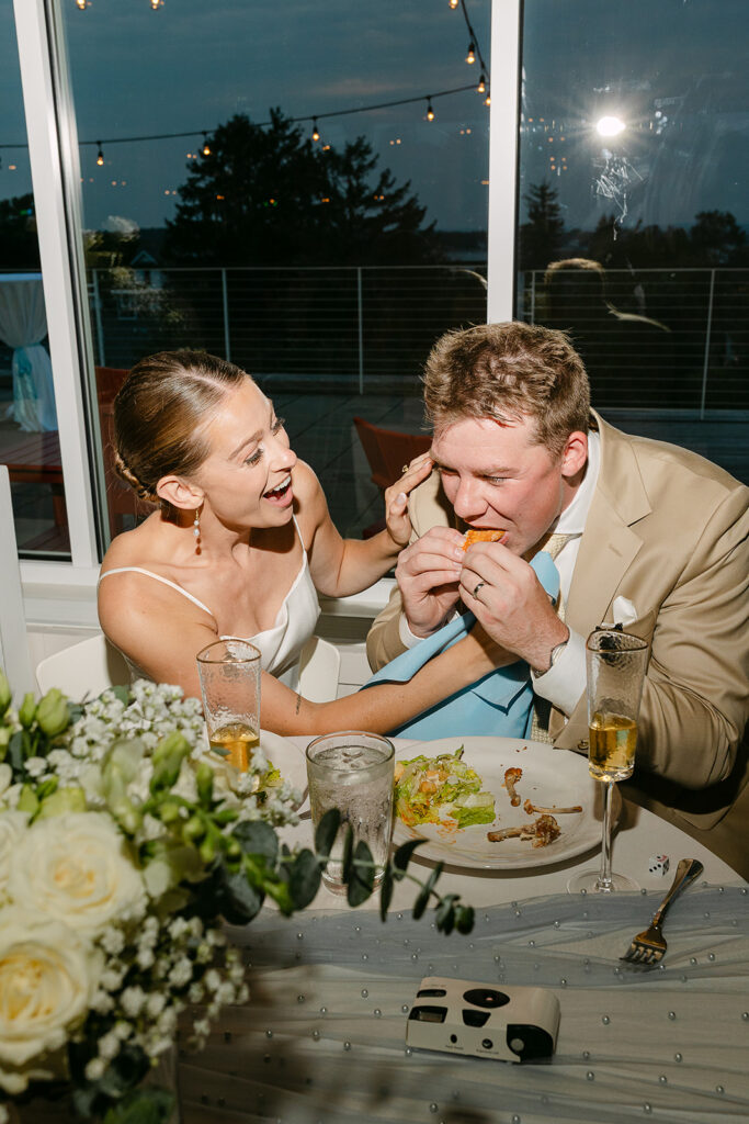 Bride and groom eating dinner together during their Door County wedding reception