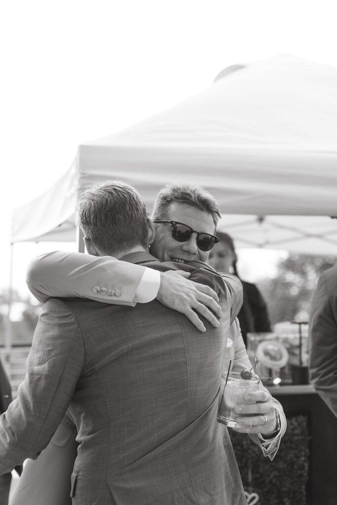 Bride hugging a guest during a relaxed cocktail hour in Door County