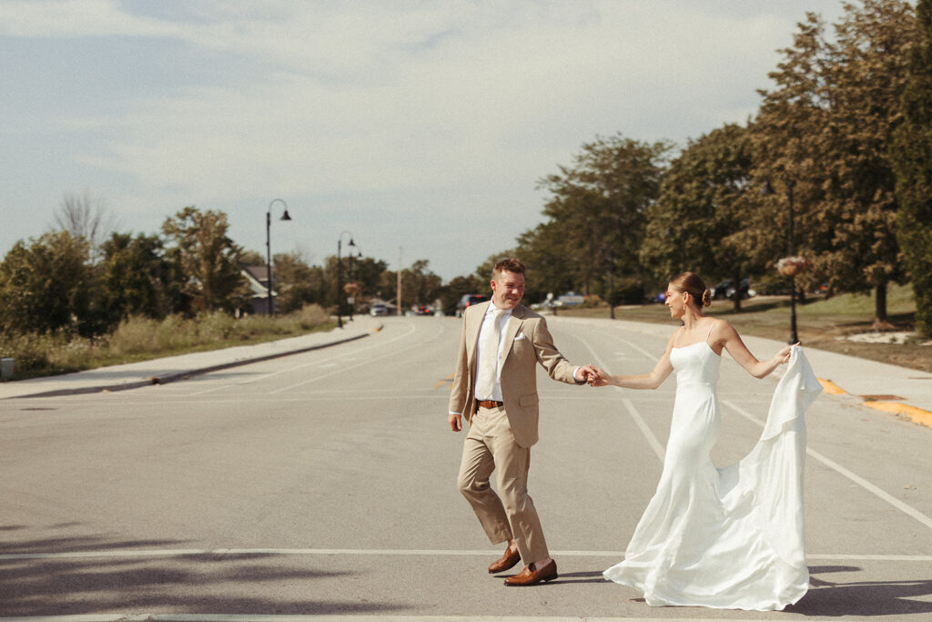 Bride and groom walking hand in hand in Egg Harbor before their Door County Wedding