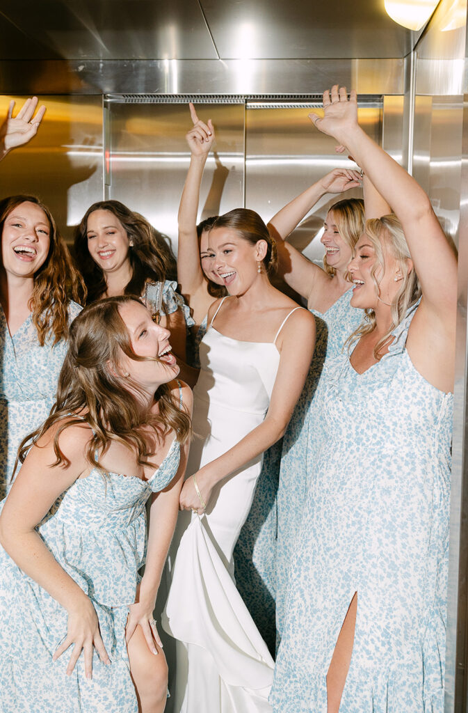 Bridesmaids celebrating together in an elevator before a fun Door County wedding day