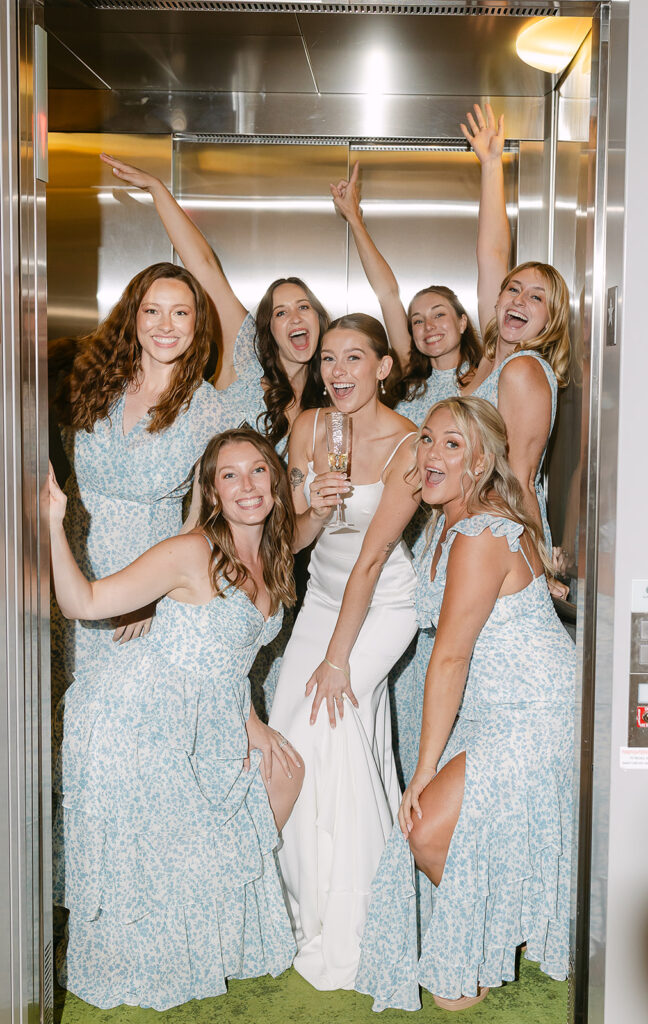 Bridesmaids celebrating together in an elevator before a fun Door County wedding day