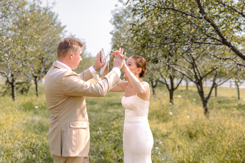 Bride and groom high five in celebration during their Door County wedding