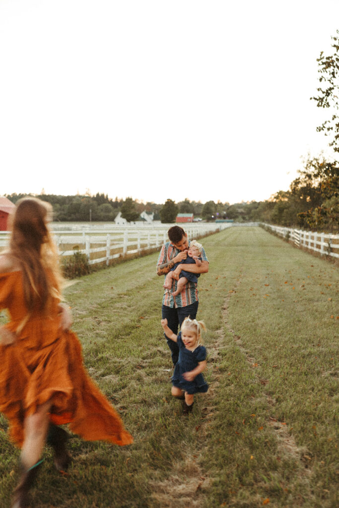 Family walking and playing together on a Wisconsin farm during a fall lifestyle family photo session.