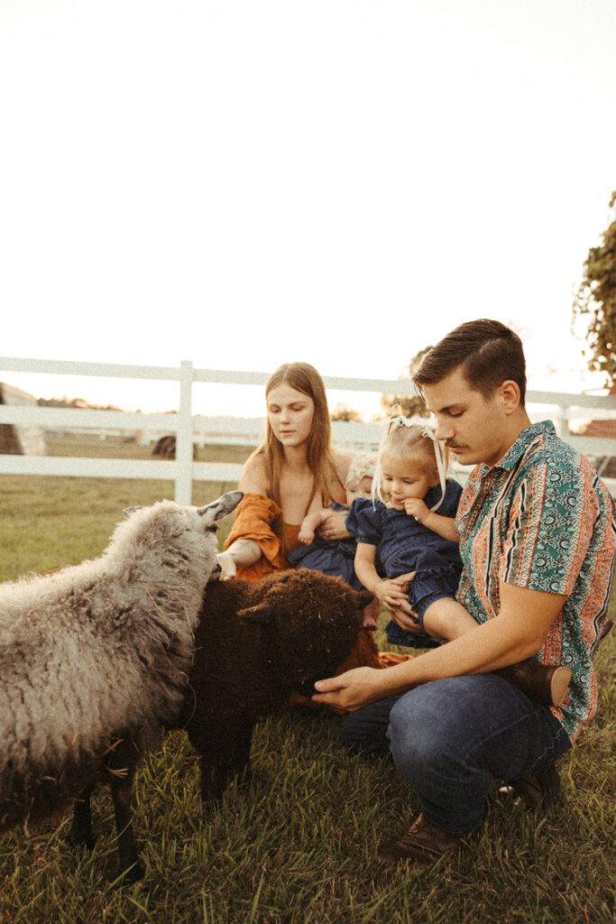 Family spending time with farm animals during a fall family session in Door County, Wisconsin.