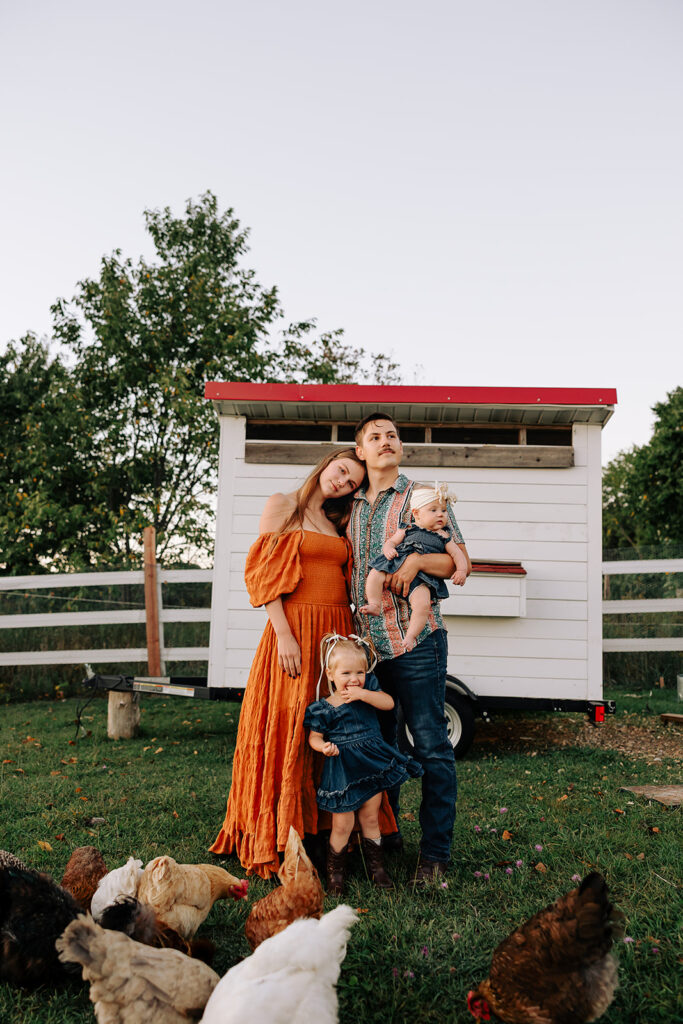 Family standing together on a farm during a fall family photo session in Door County, Wisconsin, photographed in a candid and relaxed style.