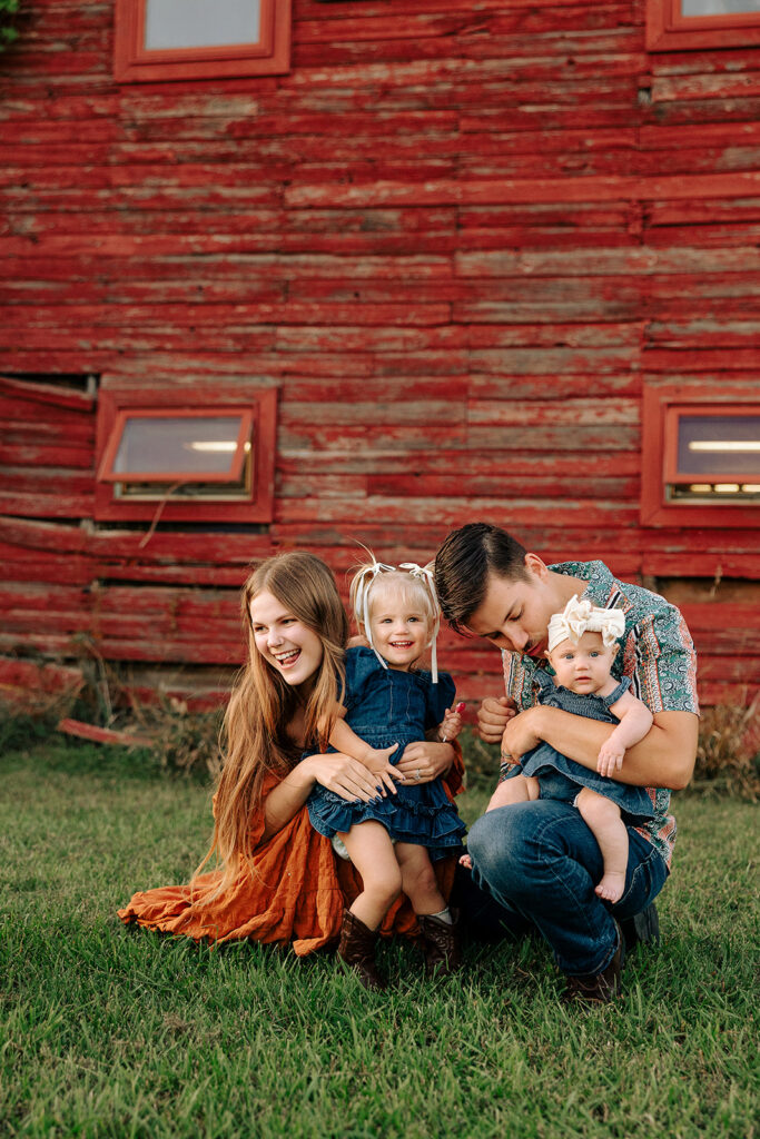 Family laughing together on a farm during a relaxed fall family photo session in Door County, Wisconsin, focused on movement and connection.