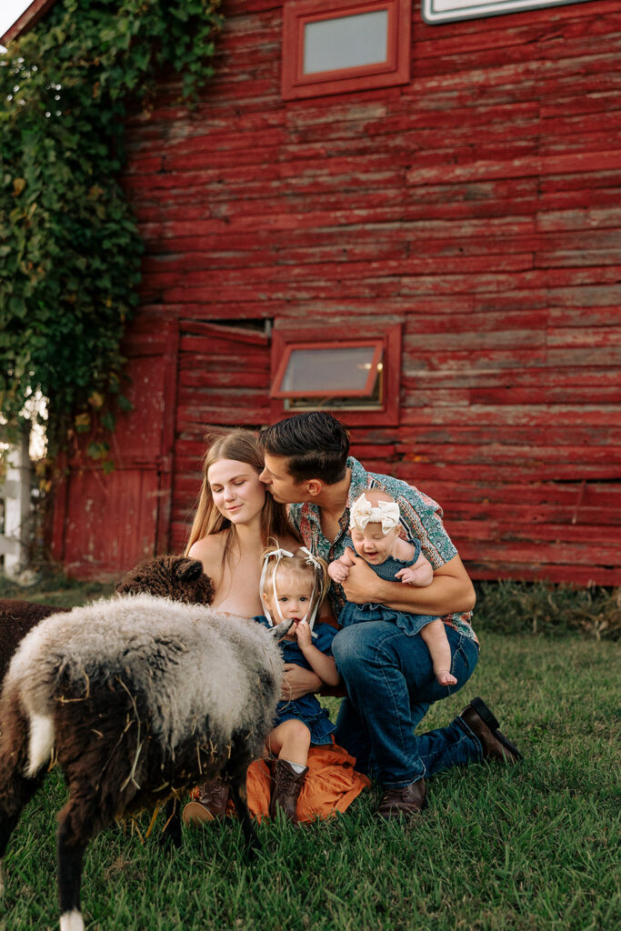 Parents and children crouching together to meet farm animals during a candid fall family session on a Door County farm.