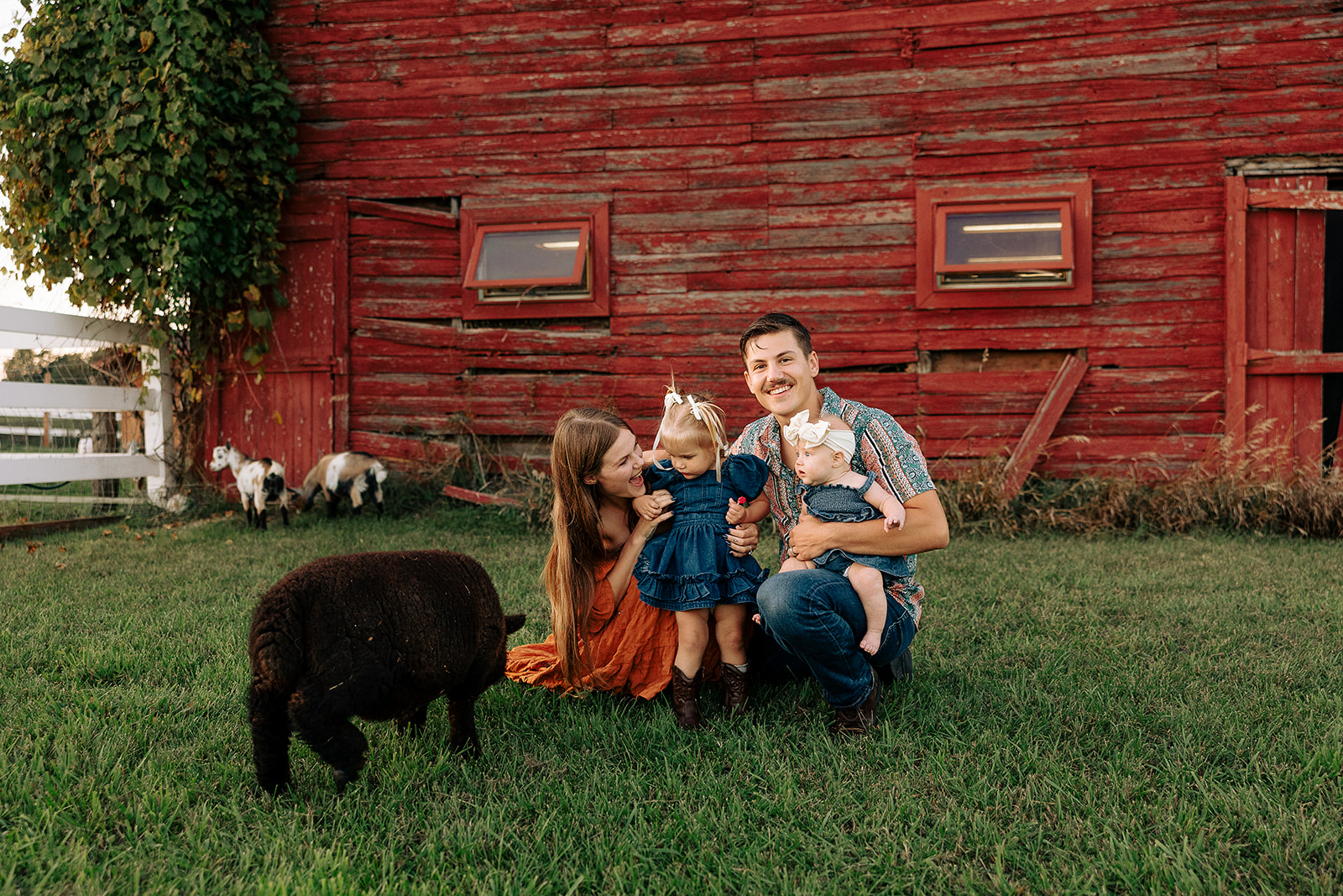 Family laughing together on a farm during a relaxed fall family photo session in Door County, Wisconsin, focused on movement and connection.